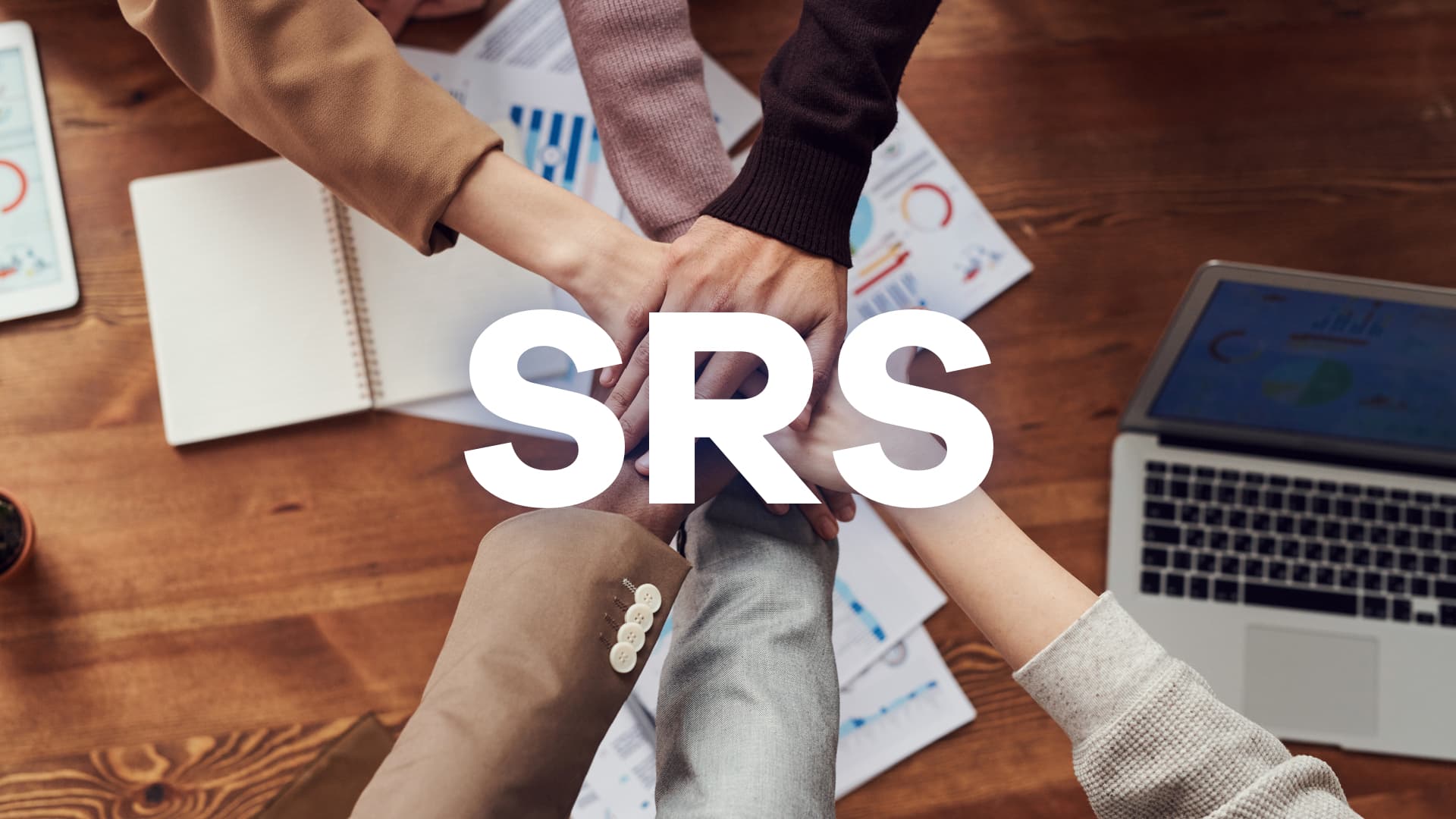 Par dessus une table des personnes se serrent les coudes